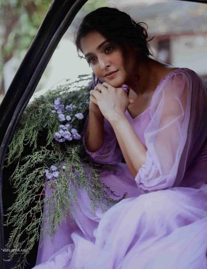 Ramya nambeesan posing inside car in lavendar colour gown