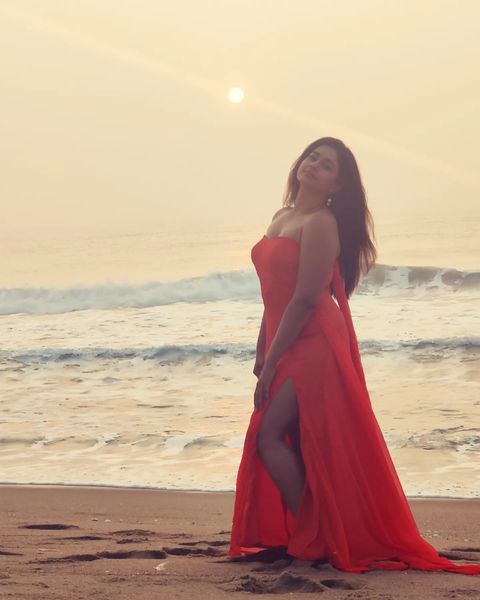 Poonam bajwa posing along seashore in hot sleeveless red dress